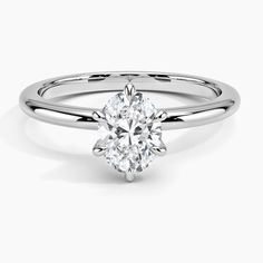 a round cut diamond engagement ring on a white background with the center stone in the middle