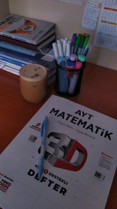 a desk with several books and pens on it