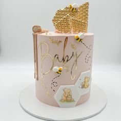 a pink and gold baby shower cake with honeycombs on it's top