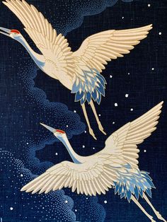 two white cranes flying through the night sky