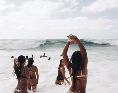 several women in bikinis are playing in the water