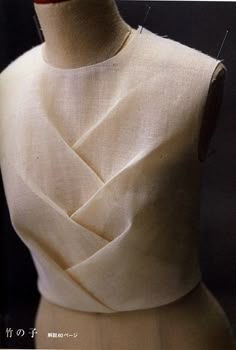 the back of a white dress on a mannequin's dummy with needles in it