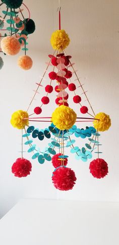 a multicolored mobile with pom - poms hanging from it's sides