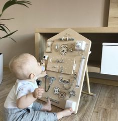 a baby sitting on the floor playing with an assortment of items in front of him