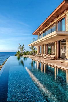 a large house with a swimming pool next to the ocean