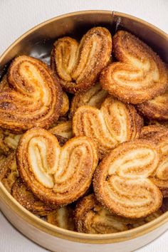 cinnamon swirl cookies in a metal bowl on a white tablecloth, ready to be eaten