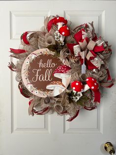 a wreath that says hello fall is hanging on a door with red and white bows