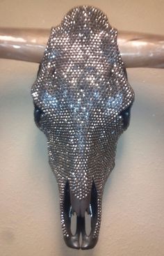 an animal's head made out of silver sequins hanging on a wall