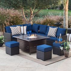 an outdoor patio furniture set with blue cushions and pillows on the floor next to a fire pit