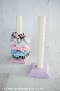 two candles are sitting next to each other on top of some cloths in front of them