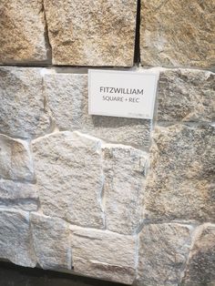 a stone wall with a sign on it that says fitzz williams square and rice