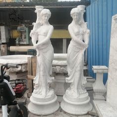 two white statues sitting next to each other