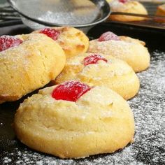 several cookies with jelly on them sitting on a baking sheet