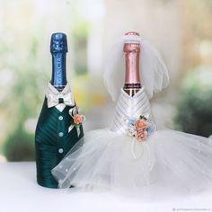 two wine bottles in tulle skirts and one with a bottle topper on it