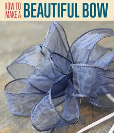 a bow made out of blue organine on top of a wooden table with text overlay