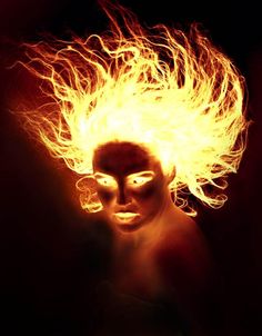 a woman's face is lit up with fire