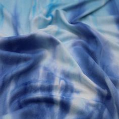 the blue and white fabric has been dyed with watercolors on it's surface