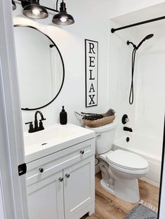 a white bathroom with black accents on the walls