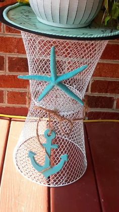 a table topped with a basket filled with flowers and an anchor on top of it