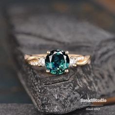 a blue and white diamond ring sitting on top of a rock