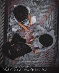 three people sitting on top of a rug