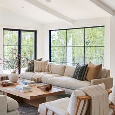 a living room filled with furniture and large windows