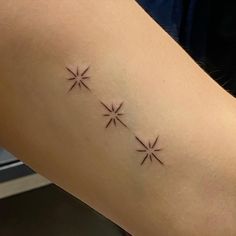 a woman's arm with three small stars on the back of her left arm