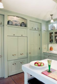 a kitchen with green cabinets and white counter tops