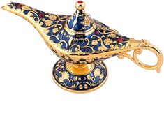 an ornate blue and gold teapot on a stand with a red jewel in the center