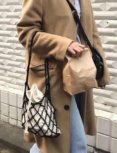 a woman walking down the street carrying a purse