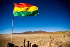 a flag in the desert with mountains in the background