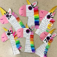 four unicorns made out of construction paper and colored pencils