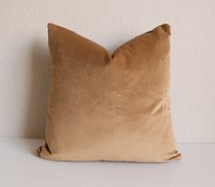 a brown pillow sitting on top of a white table