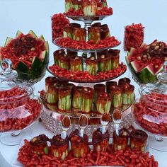 a table topped with lots of different types of candies and watermelon slices