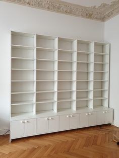 an empty room with white bookcases and wood flooring on the wooden floor