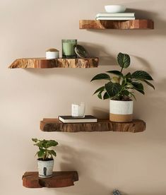 three wooden shelves with plants and candles on them