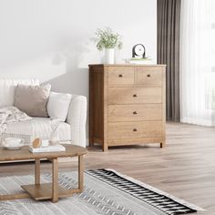 a living room with a white couch, coffee table and dresser in front of it