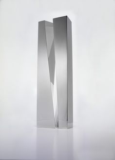 a tall metal object is shown against a white background with the light reflecting off it's side