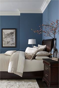 a bedroom with blue walls and white bedding