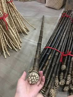 a person is holding some kind of item in front of many bamboo poles and sticks