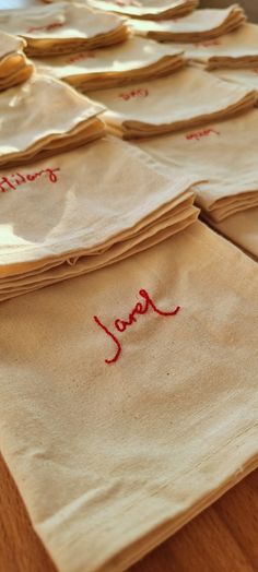 many pieces of cloth with red writing on them sitting on a wooden table next to each other