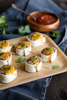 small appetizers are arranged on a wooden platter