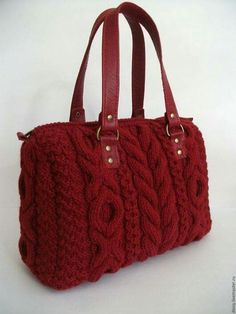 a red handbag sitting on top of a white table