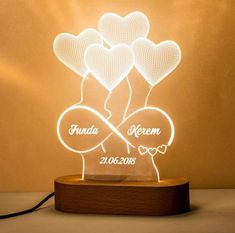 a light up heart shaped lamp with the name robert and two hearts in it on a wooden stand