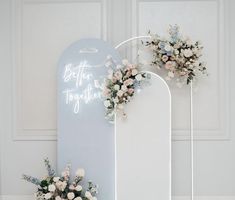 two flowers are placed on the back of a white sign that says, better together