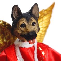 a dog figurine wearing a red coat and gold wings