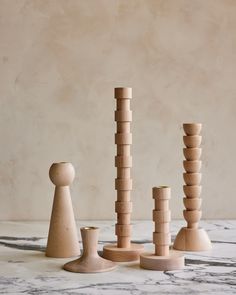 several wooden pegs are stacked on top of each other in front of a marble background