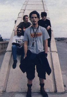 a group of young men standing on top of a bridge