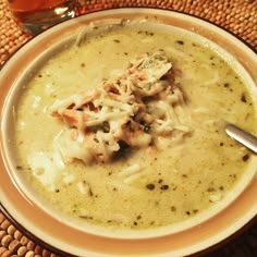 a bowl filled with soup on top of a woven place mat next to a spoon