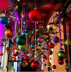 an assortment of christmas ornaments hanging from the ceiling